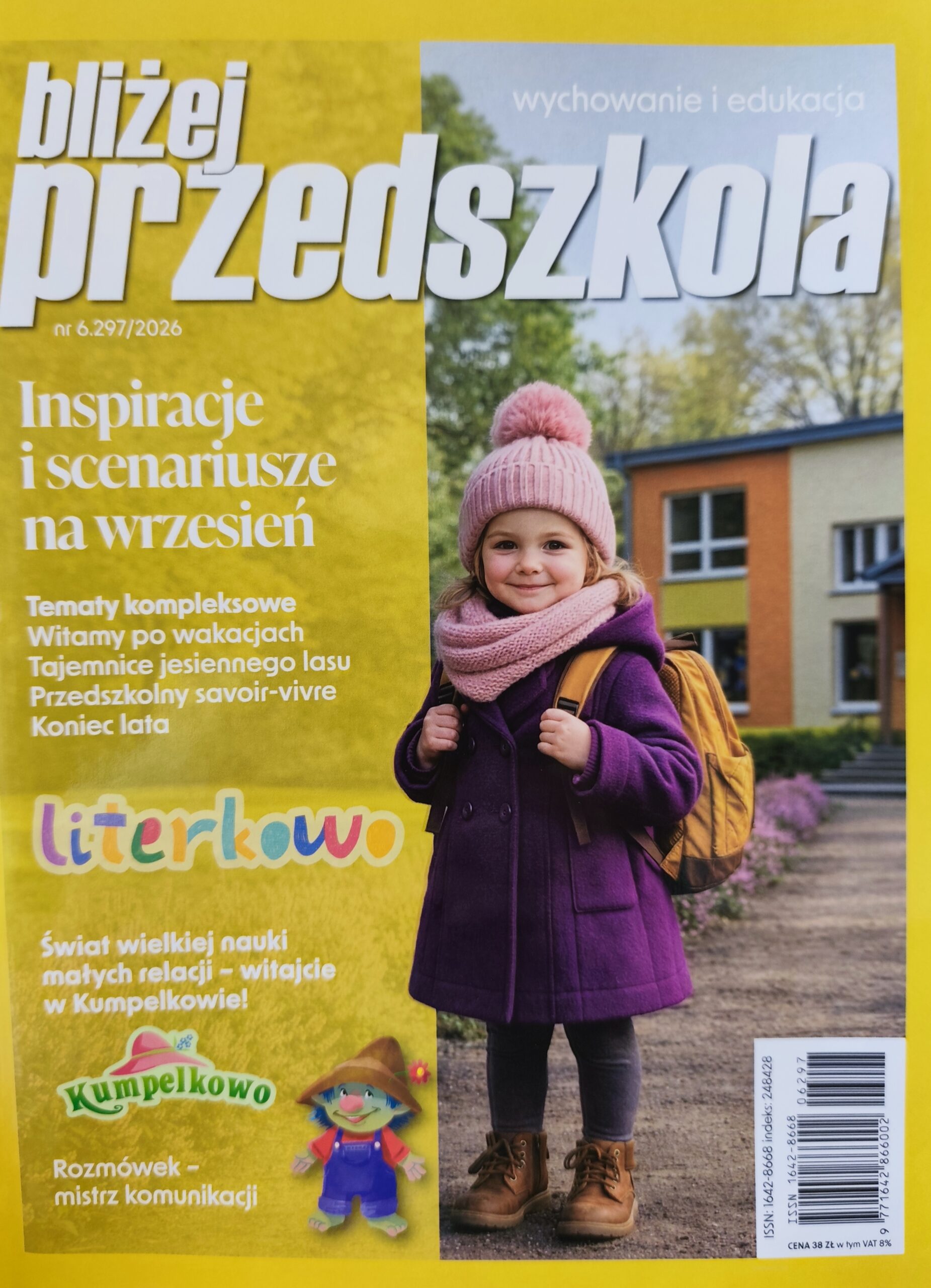 Na okładce mała dziewczynka w fioletowym płaszczu i różowej czapce z plecakiem na plecach. W tle widoczny jest budynek przedszkola. Poniżej stworek w czerwonej koszulce i fioletowych spodenkach, tzw. Rozmówek.
